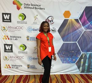Ruth Ikegah stands in front of a poster that says 'Data Science Without Borders' and includes logos of participating organisations including OSPO Now